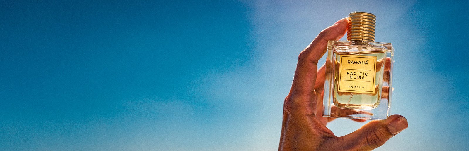 Rawaha perfume bottle held up to the sky